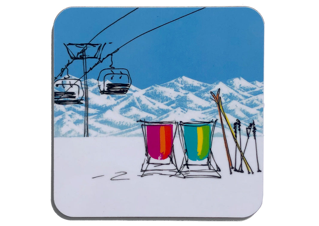 Art coaster of 2 deckchairs in the snow with skis, ski lift and mountain backdrop by artist Hannah van Bergen