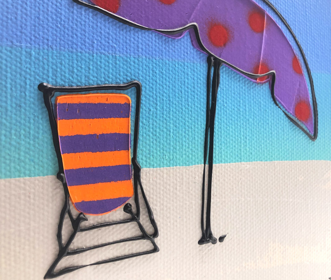 Close up of original textured mini canvas painting of a colourful deckchair and parasol on the beach with blue sky by artist Hannah van Bergen