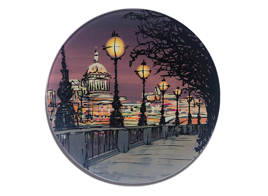Round glass platter / worktop saver with artwork of Southbank in London at dusk with street lamps and St Pauls Cathedral in the background by artist Hannah van Bergen