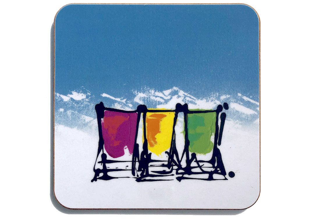Colourful art coaster of 3 deckchairs in the snow with blue sky and mountain backdrop by artist Hannah van Bergen