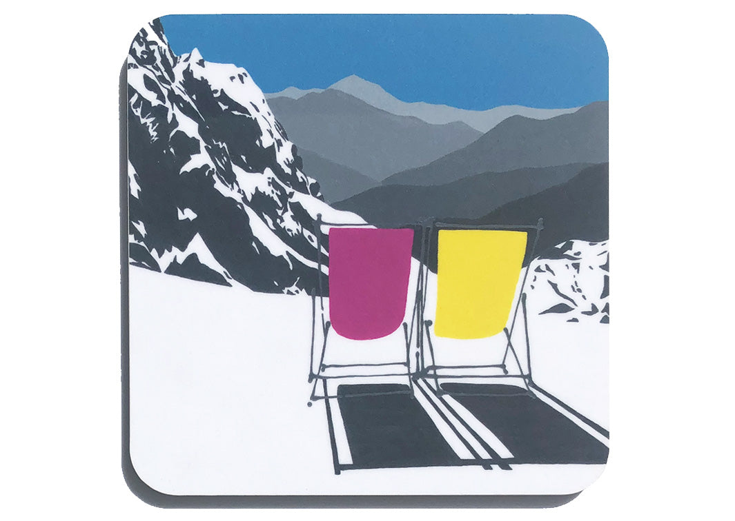 Art coaster of 2 pink and yellow deckchairs in the snow with blue sky and mountain backdrop by artist Hannah van Bergen