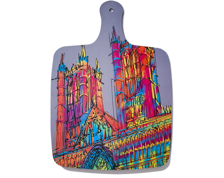 Melamine chopping board with handle and artwork of a colourful Lincoln Cathedral on grey background by artist Hannah van Bergen