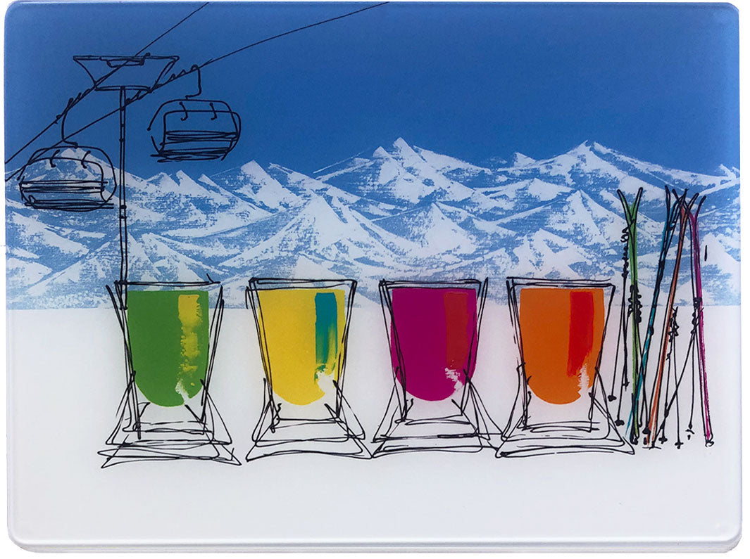 Glass platter / worktop saver with artwork of 4 colourful deckchairs in the snow with mountain backdrop, skis and chair lift by artist Hannah van Bergen