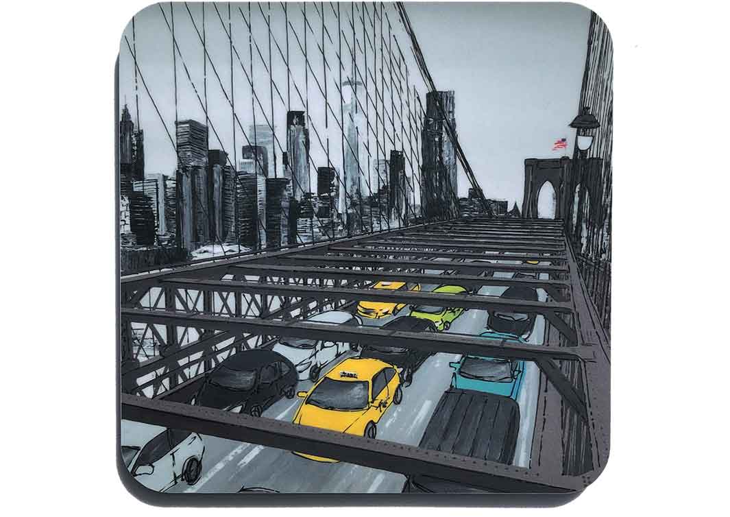 Art coaster of lower Manhattan skyline through Brooklyn Bridge by artist Hannah van Bergen. Mostly greyscale with yellow and green taxis 