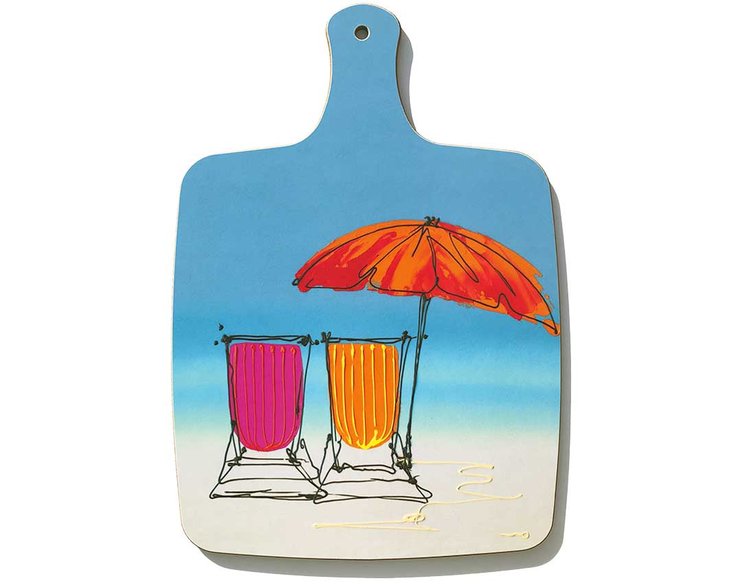 Chopping board with handle featuring artwork of 2 deckchairs and parasol on the beach by artist Hannah van Bergen